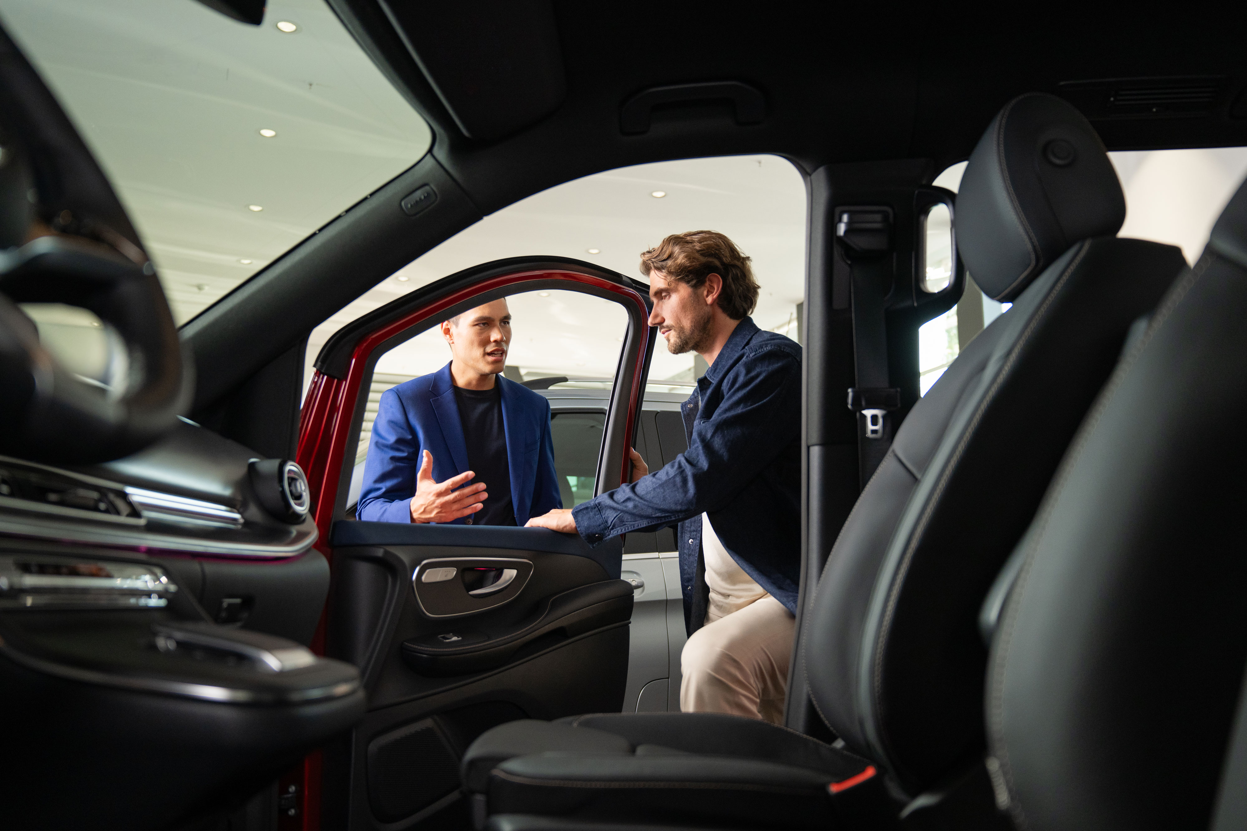 Versicherung | Financial Services | Mercedes-Benz Transporter Eine Aufnahme aus dem Innenraum, die zwei Personen zeigt, die die Beifahrertür öffnen.