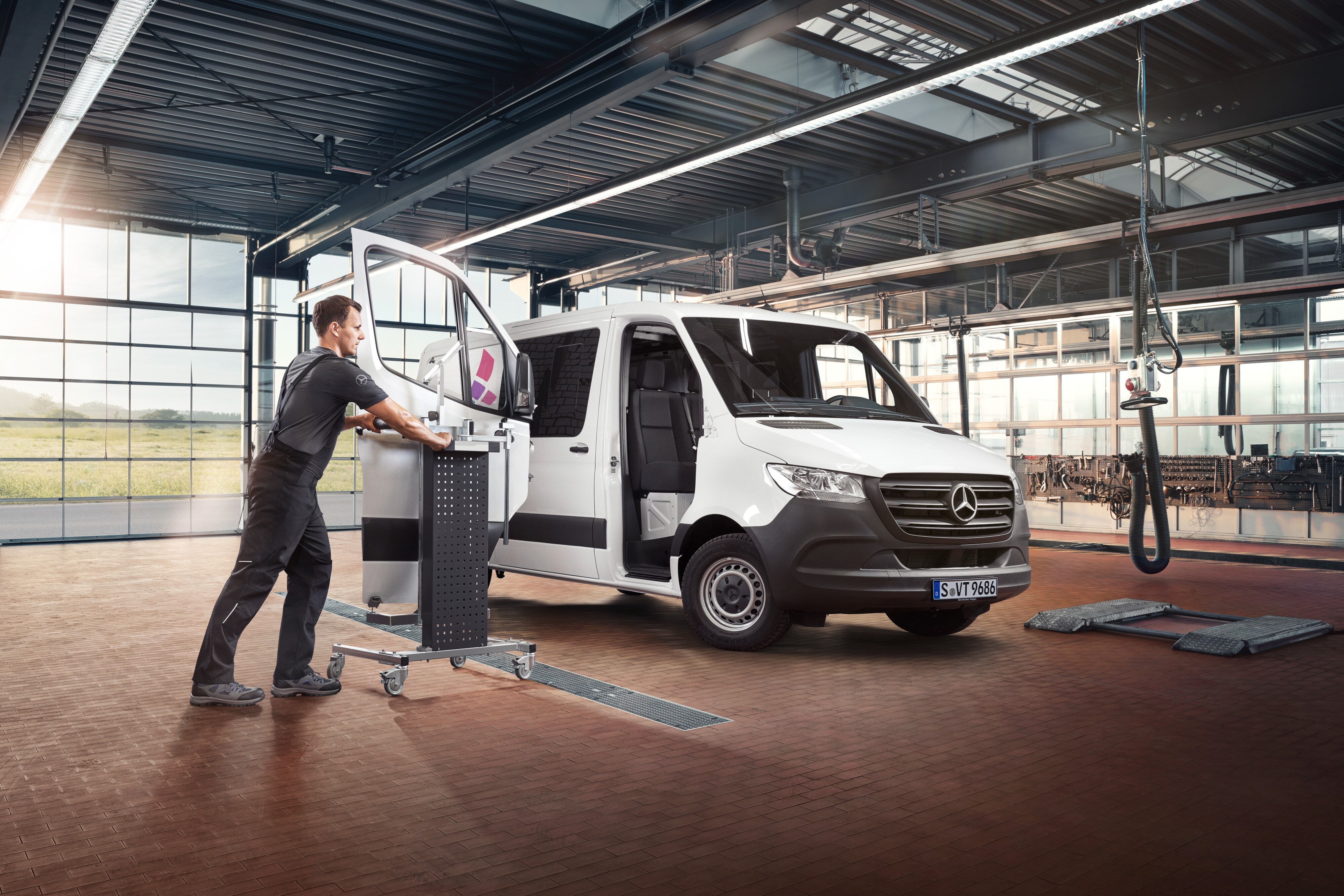 Mercedes-Benz | Serviceübersicht | Reparatur Ein Techniker wartet die Beifahrertür eines weißen Mercedes-Benz Sprinter Transporters.